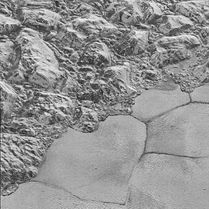Mountains of ice along a portion of smoother ice planes on Pluto’s surface.